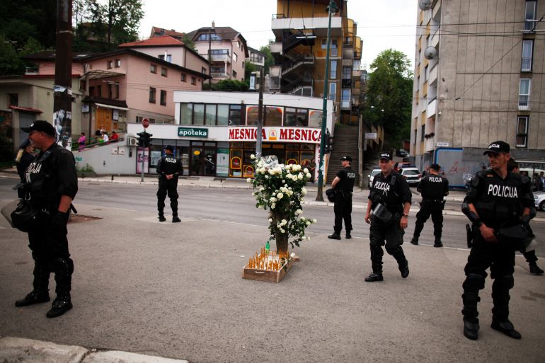 Members of the special police take their positions and keep watch over flowers and candles placed after a commemoration in Dobrovoljacka street in Sarajevo, May 3, 2012