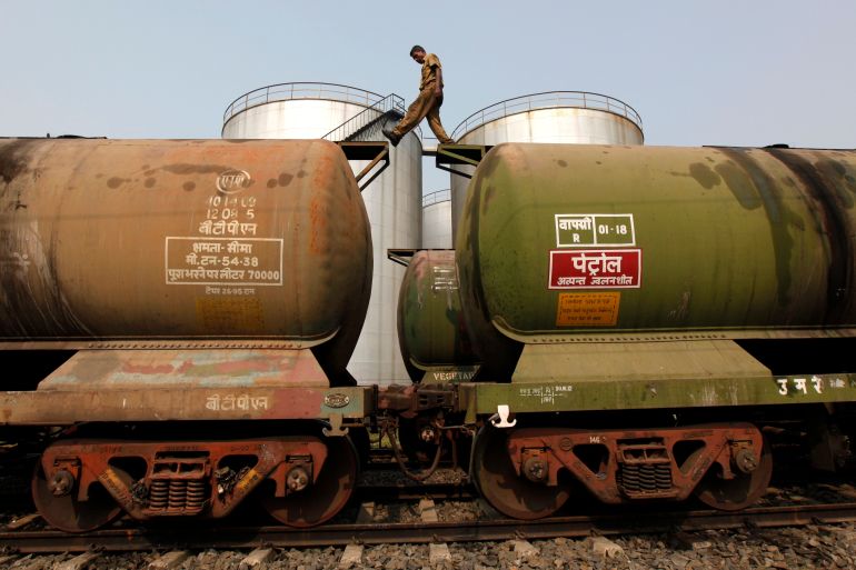 A worker walks atop a tanker wagon at an oil terminal on the outskirts of Kolkata, India