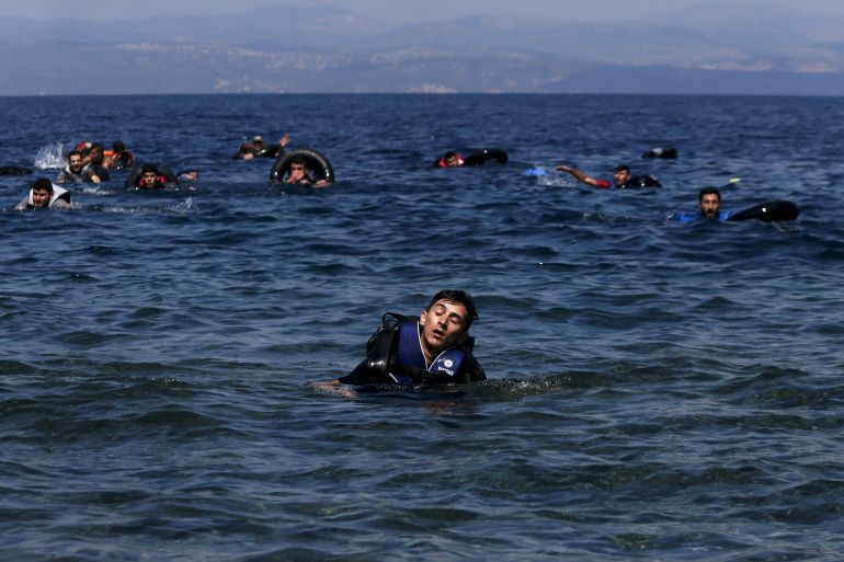 A refugee is seen swimming towards the shore near the Greek island of Lesbos
