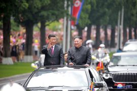 Chinese president Xi Jinping stands in an open top car with North Korean leader Kim Jong Un as he was welcomed to Pyongyang in June 2019