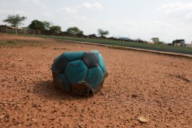 A deflated football is seen on the sidelines of a football field in Nigeria