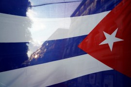 A silhouette of the city is seen through a Cuban flag