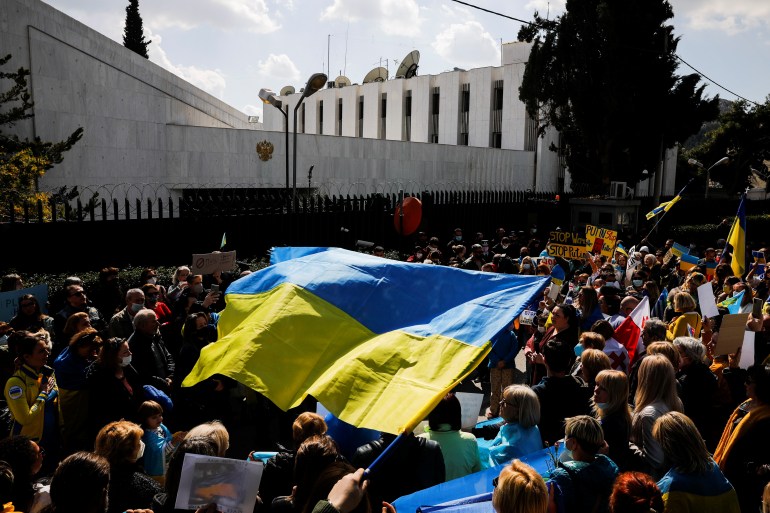 Ukrainians living in Greece hold Ukrainian flags and placards as they take part in a protest against Russia's military operation in Ukraine, outside the Russian Embassy in Athens