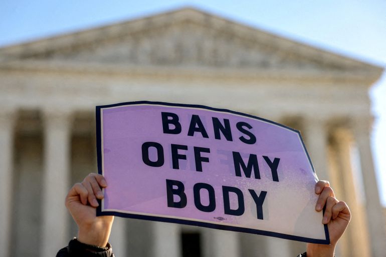 A protester holds a sign that reads 'Bans off my body'