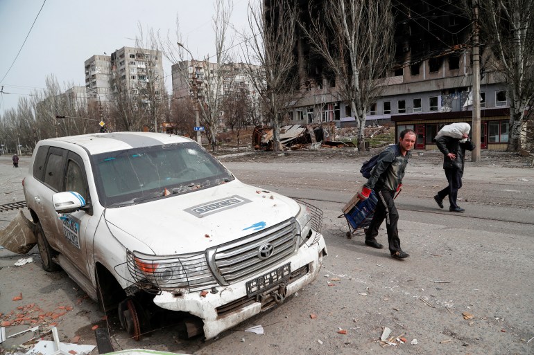 A damaged OSCE car by the side of the road in the besieged city of Mariupol