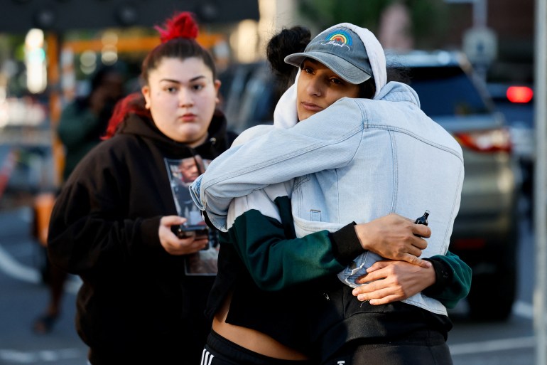 People hug at the site of a deadly shooting in Sacramento