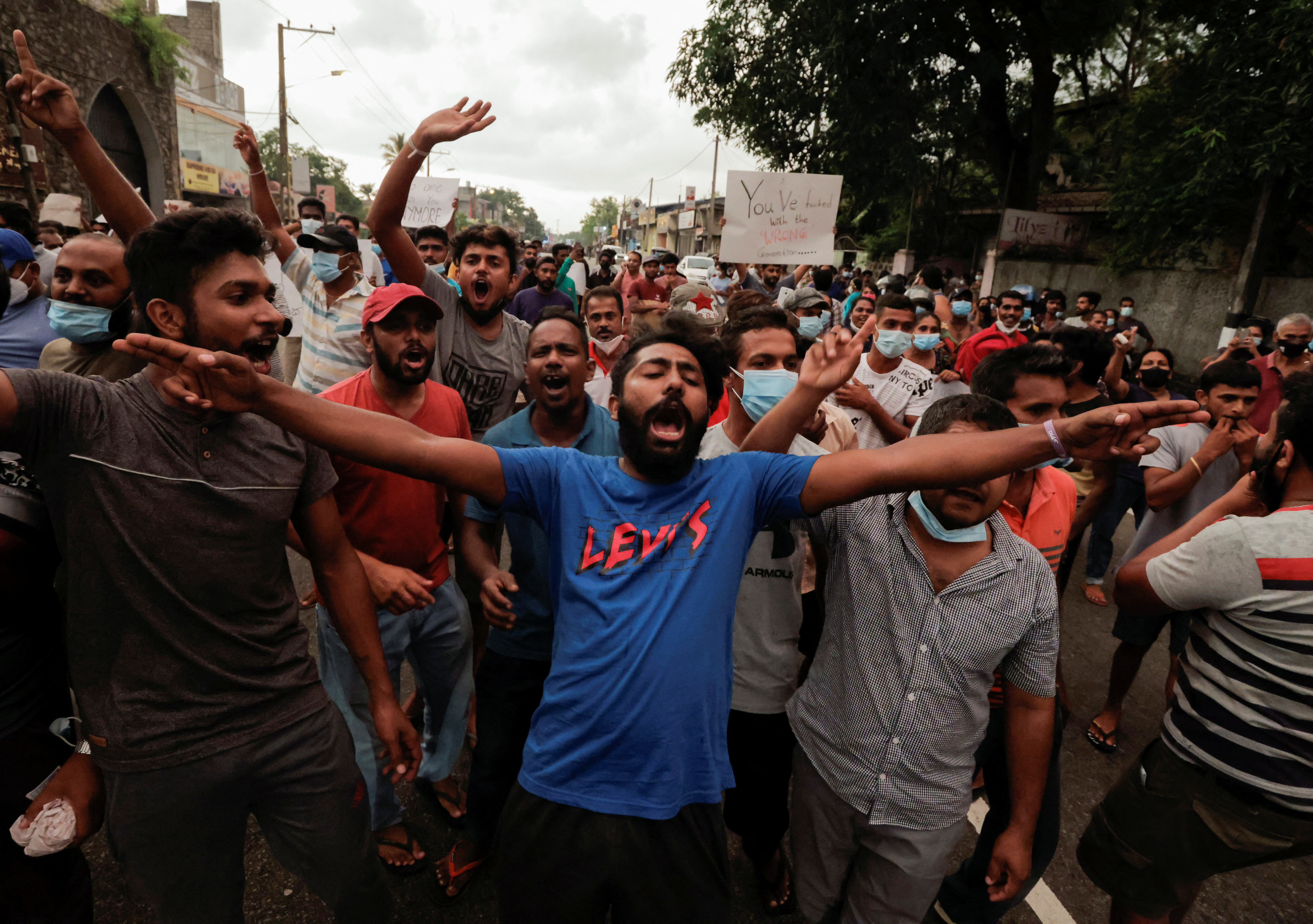 La gente grida slogan contro il presidente dello Sri Lanka Gotabaya Rajapaksa in una zona residenziale di Colombo dopo che il governo ha imposto il coprifuoco