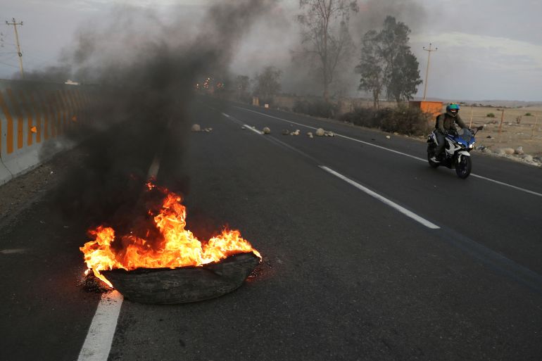 A burning tire serves as part of a blockade of a highway to Lima during a national transportation strike against gas prices and toll road rates, in Ica, Peru April 4, 2022