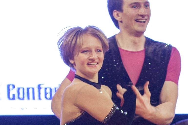 Katerina Tikhonova with short blonde hair and wearing a black sparkly leotard, daughter of Russian President Vladimir Putin, dances with a partner during the World Cup Rock'n'Roll Acrobatic Competition in Krakow, Poland, in April 2014.