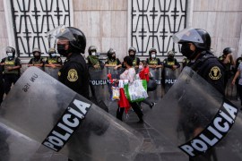 Police officers stand guard as demonstrators rally in Lima, Peru.