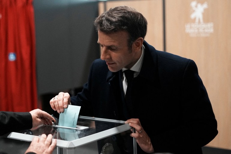 French President and centrist presidential candidate for reelection Emmanuel Macron casts his ballot on the day of the first round of the presidential election