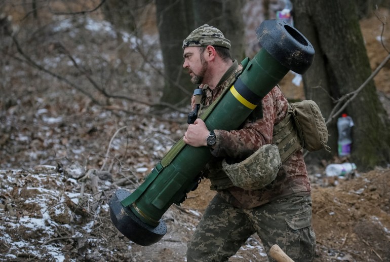 Ukrayna servisinin bir üyesi, Kiev'in kuzey bölgesinde cephe hattında bir konumda bir Javelin füze sistemi tutuyor [File: Gleb Garanich/Reuters]