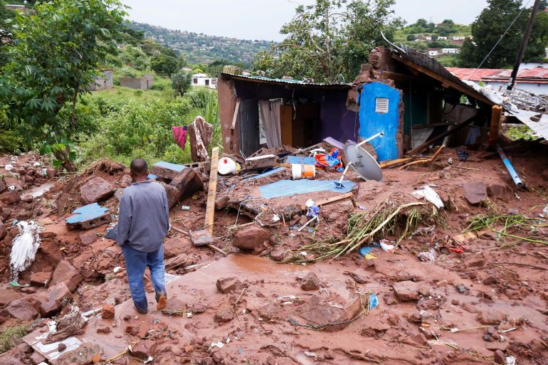 Jomba Phiri walks over where his house stood after heavy rains caused flood damage in KwaNdengezi, Durban