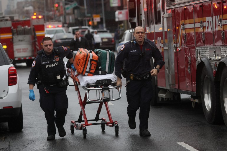Emergency personnel work near the scene of a shooting at a subway station in the Brooklyn