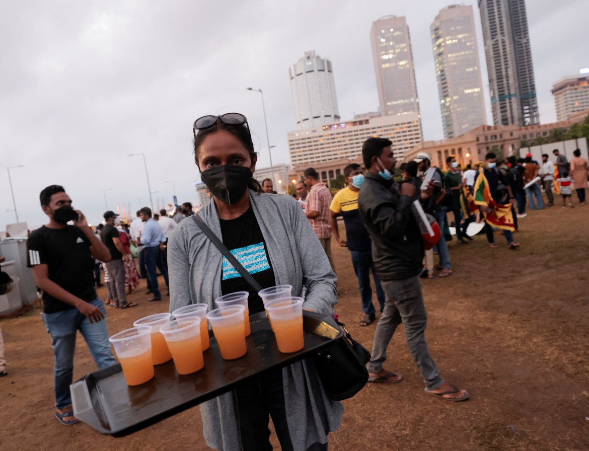 A person serves beverages to other demonstrators inside a protest area