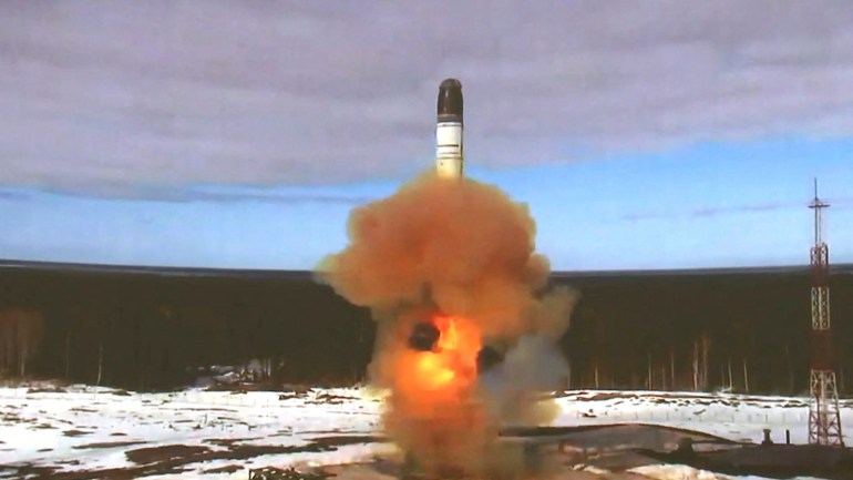 The Sarmat intercontinental ballistic missile being launched during a test at Plesetsk cosmodrome in Russia's Arkhangelsk region. A plume of bright orange flames and orange-tinged smoke appear around and underneath the missile.