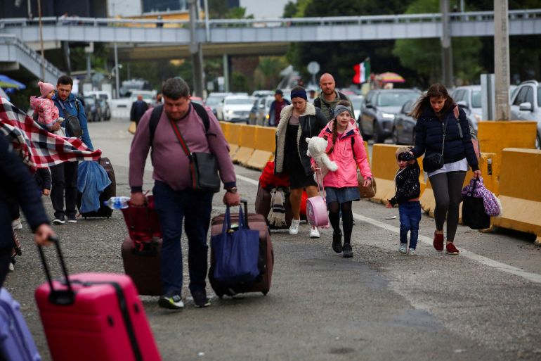 Ukrainians who fled to Mexico walk towards US border crossing