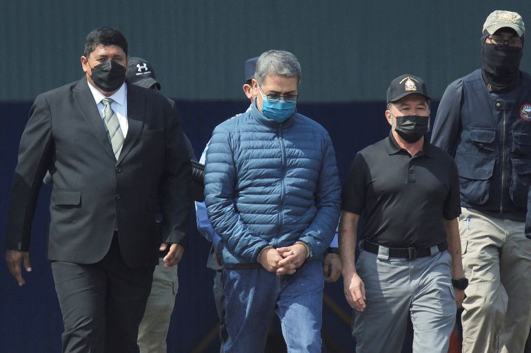 Honduras former President Juan Orlando Hernandez walks towards a US Drug Enforcement Agency plane for his extradition to the United States