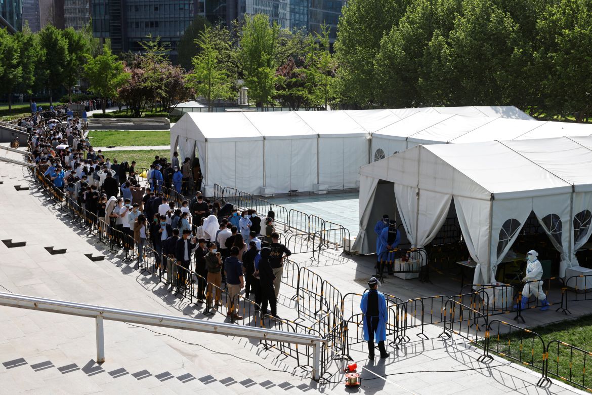 People line up outside a makeshift nucleic acid testing site during a mass testing for the coronavirus disease (COVID-19) in Haidian district of Beijing