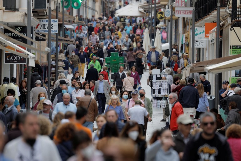 People walk along La Bola shopping street in Ronda, southern Spain