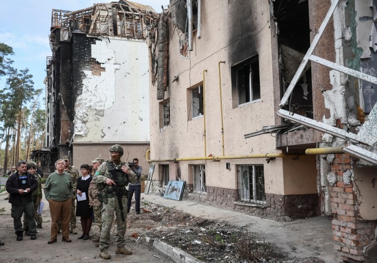 UN Secretary-General Antonio Guterres next to a destroyed building on a visit to the town of Irpin outside of Kyiv