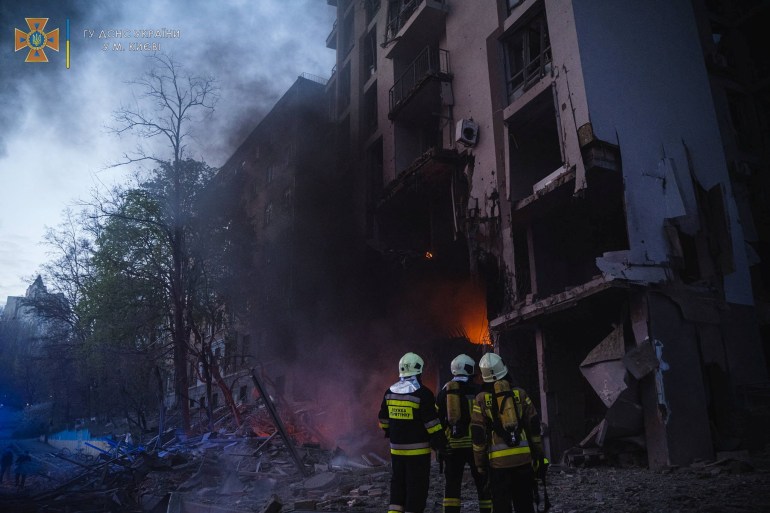 Rescuers work at a site of a residential building damaged by a missile strike