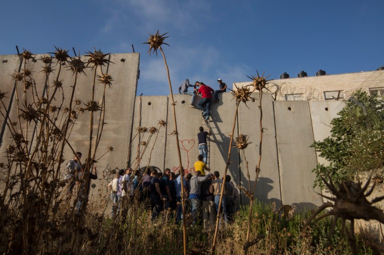 Palestinians scale Israel's separation wall