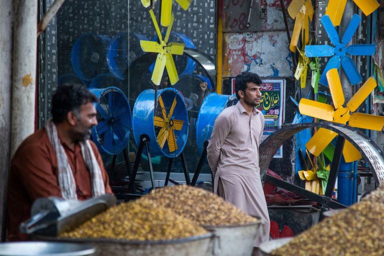 A man stands in front of fan blades in Lahore, Pakistan