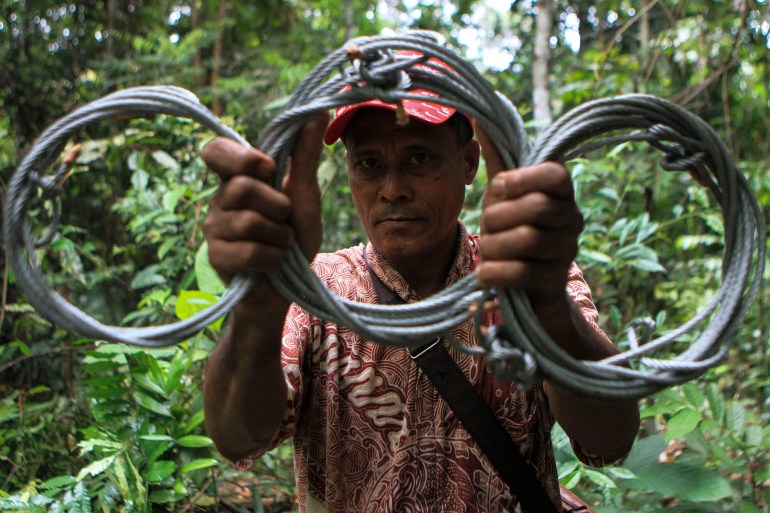 A man holds up snares used to catch wild animals in Sumatra