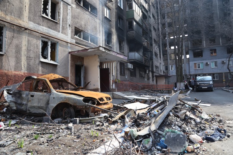 A view of destroyed buildings and a vehicle during ongoing conflict in the city of Mariupol