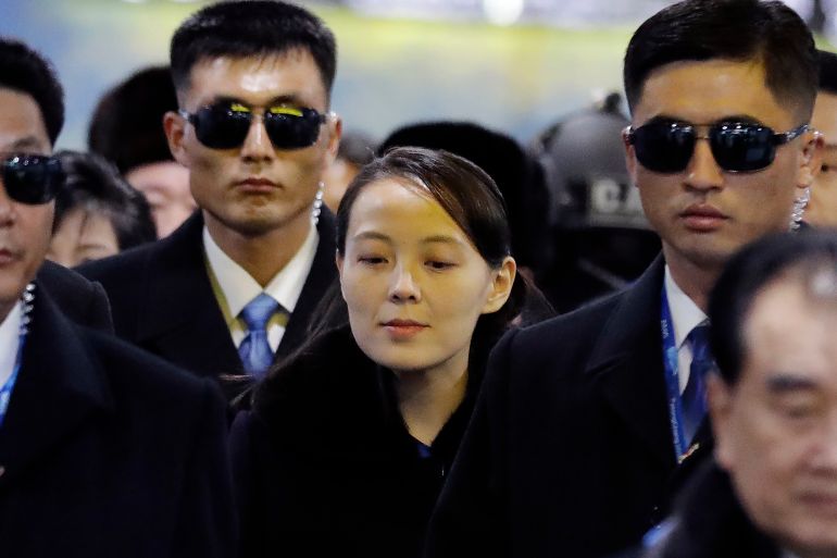 North Korea's Kim Yo Jong arriving in South Korea in 2018 flanked by two male bodyguards in dark glasses