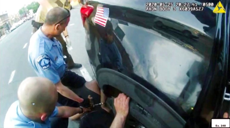 image from police body camera video shown as evidence in court, paramedics arrive as Minneapolis police officers, including Derick Chauvin, second from left, and J. Alexander Kueng restrain George Floyd in Minneapolis, on May 25, 2020.