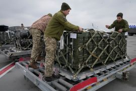Ukrainian service members unpack US assistance at an airport outside Kyiv