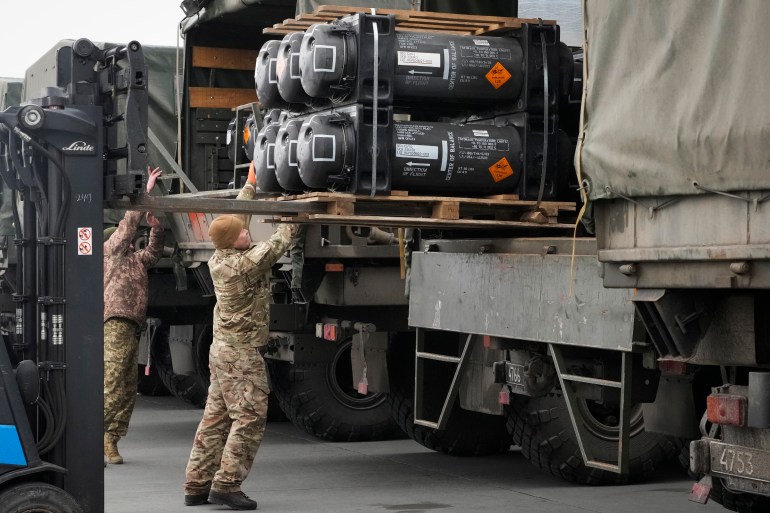 Ukrainian service members load Javelin anti-tank missiles onto a truck