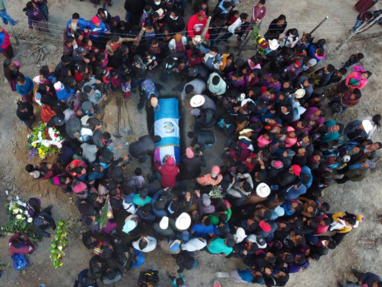People lower the remains of Elfego Miranda Diaz into a grave, one of the Guatemalan migrants who was killed near the U.S.-Mexico border.