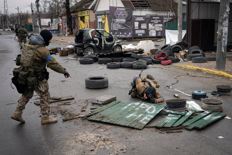 Ukrainian servicemen check streets for booby traps in the formerly Russian-occupied Kyiv suburb of Bucha, Ukraine