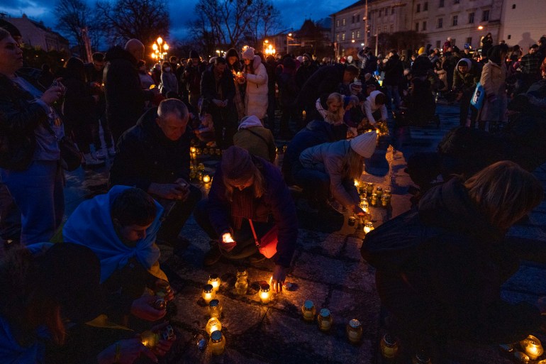 People light candles forming the shape of Ukraine's map, in memory of lost lives, in front of the Taras Shevchenko monument, in Lviv, western Ukraine, 