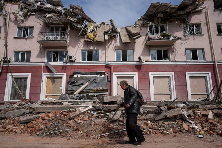 A man walks past a building damaged by shelling in Chernihiv, Ukraine, Thursday, April 7, 2022. (AP Photo/Evgeniy Maloletka)