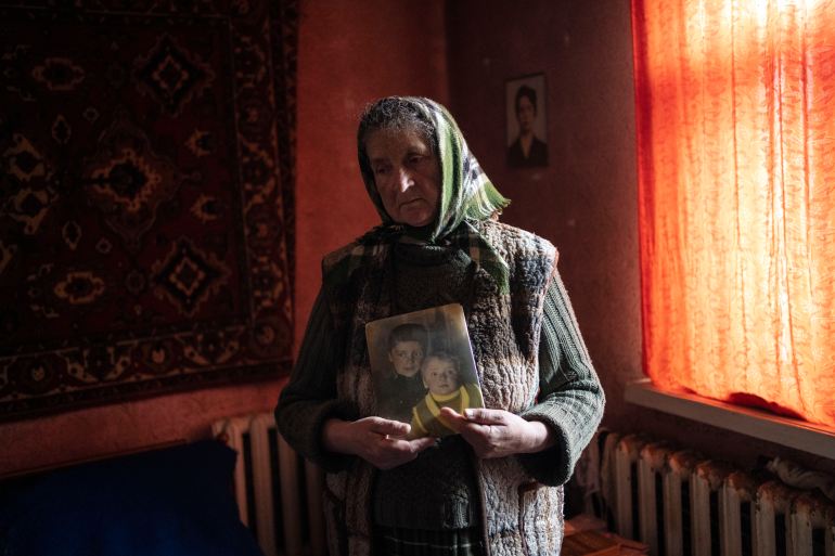 Nadiya Trubchaninova, 70, stands in her bedroom holding a portrait of her sons Oleg Trubchaninov, 46, and Vadym, 48, who was killed by Russian soldiers last March 30 in Bucha, in the outskirts of Kyiv
