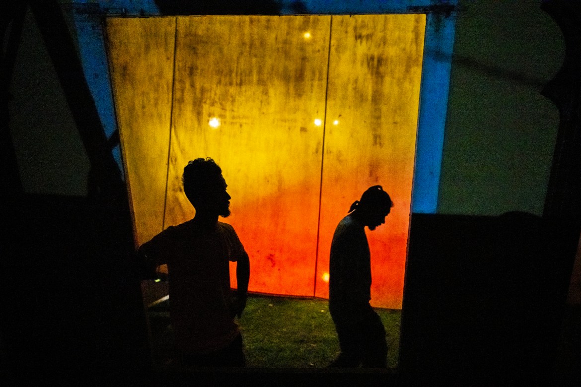 Stage workers wait to prepare a set for a performance of Awahan traveling theater at Xetali village east of Gauhati,