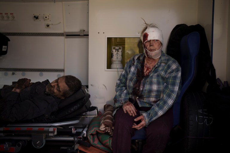 Injured civilians sit in an ambulance before being taken to a hospital after a Russian attack in Kharkiv,