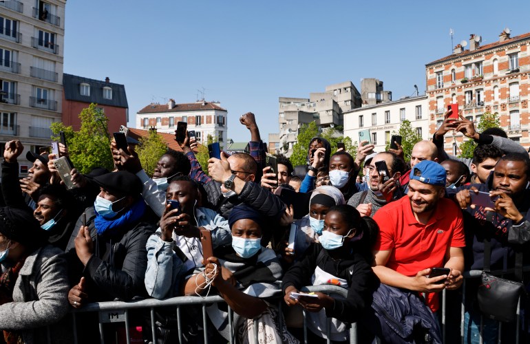 Sakinler, 21 Nisan 2022 Perşembe günü Paris'in dışında Saint-Denis'te bir kampanya durağı sırasında merkezci başkan adayı ve Fransa Cumhurbaşkanı Emmanuel Macron'u izliyorlar.