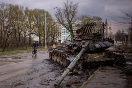 A man rides his bicycle next to a destroyed Russian tank in Chernihiv, Ukraine [Emilio Morenatti/AP Photo]