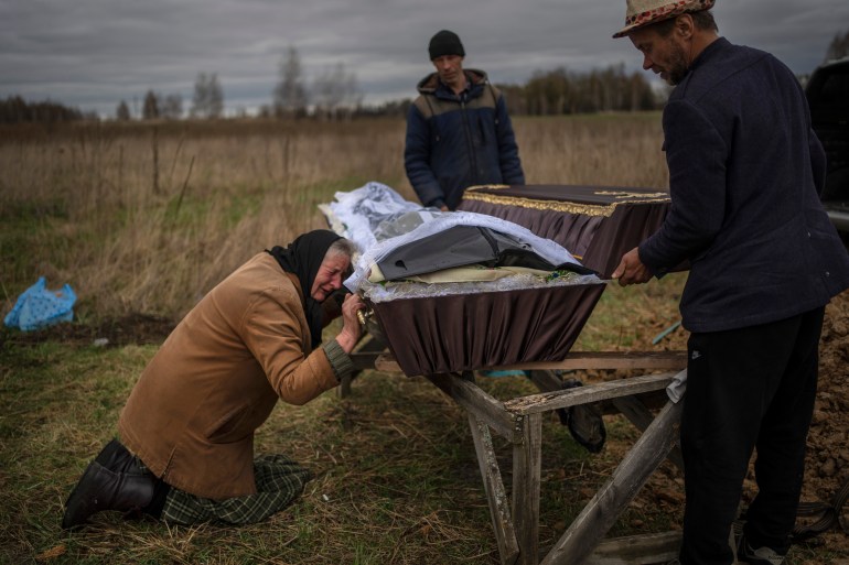Nadiya Trubchaninova, 70, cries while holding the coffin of her son Vadym, 48, who was killed by Russian soldiers last March 30 in Bucha, during his funeral in the cemetery of Mykulychi, on the outskirts of Kyiv, Ukraine, Saturday, April 16, 2022. After nine days since the discovery of Vadym's body, finally Nadiya could have a proper funeral for him. (AP Photo/Rodrigo Abd)