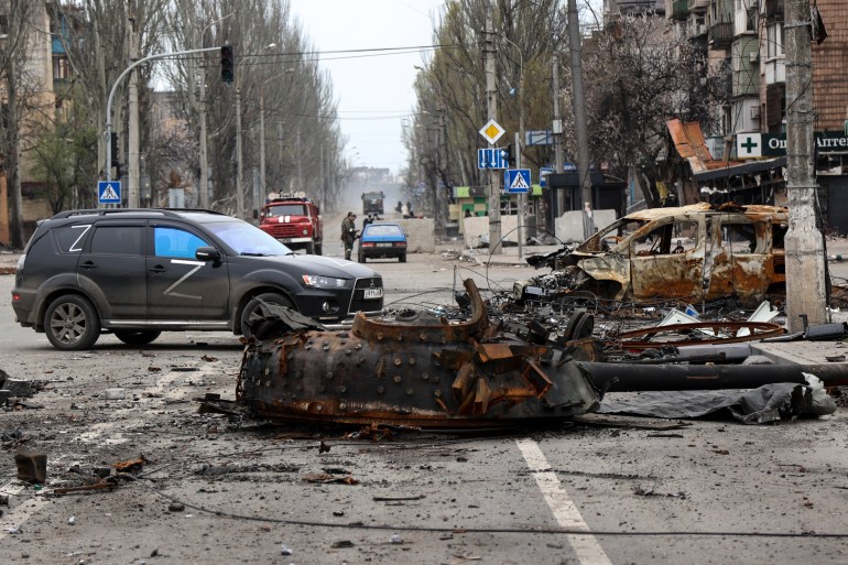 A part of a destroyed tank and a burned vehicle sit in an area controlled by Russian-backed separatist forces in Mariupol, Ukraine
