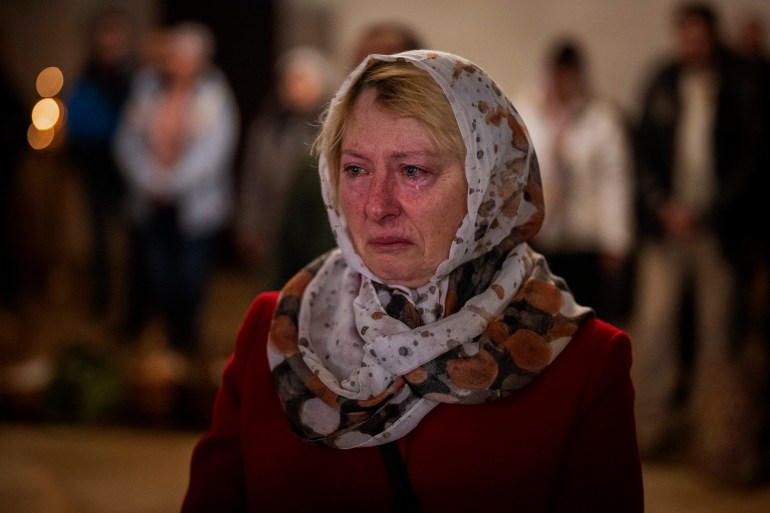 Olga Zhovtobrukh, 55, cries during an Easter religious service celebrated at a church in Bucha, on the outskirts of Kyiv