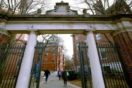 file photo, a gate opens to the Harvard University campus in Cambridge, Mass.