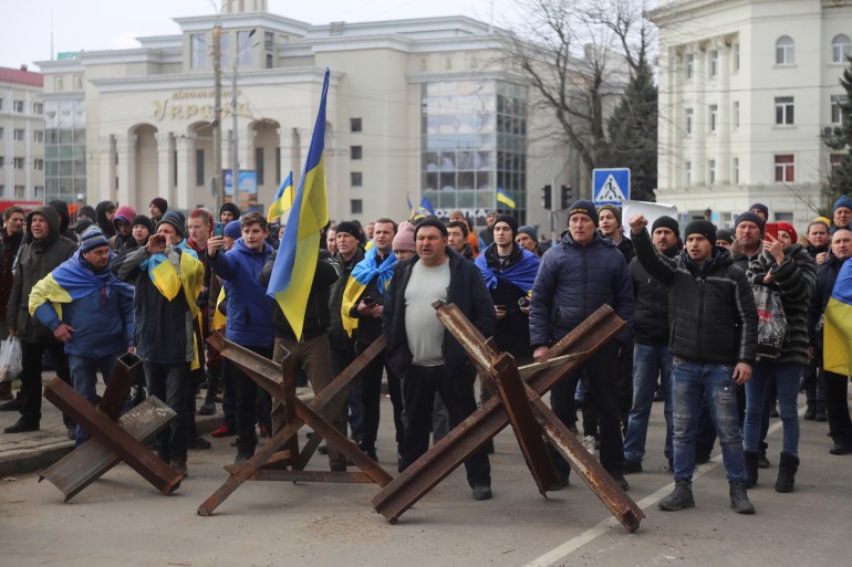 7 Mart 2022 Pazartesi günü Ukrayna'nın Kherson kentindeki Svobody Meydanı'nda (Özgürlük) Rus işgaline karşı bir gösteri sırasında insanlar Rus ordusu askerlerini çağırıyor. Rus kuvvetleri Mart ayı başlarında Ukrayna'nın güneyindeki Kherson şehrini aldığından beri.