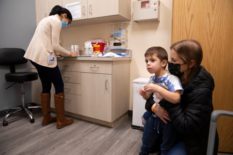  Ilana Diener holds her son, Hudson, 3, during an appointment for a Moderna COVID-19 vaccine trial in Commack, N.Y.