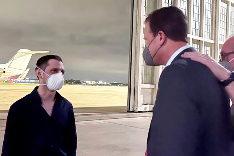 Trevor Reed, left, a Texas resident arrested in Russia in 2019, is greeted by US Representative August Pfluger at a military airfield in Texas.
